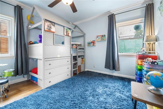 bedroom featuring hardwood / wood-style floors, ornamental molding, and ceiling fan