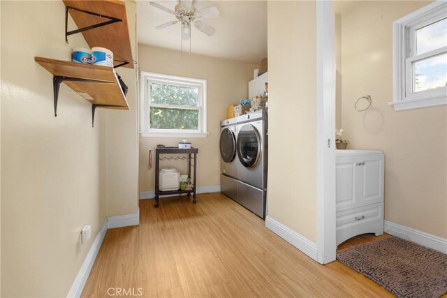 laundry room with cabinets, washing machine and dryer, ceiling fan, and light hardwood / wood-style floors