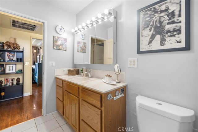 bathroom featuring vanity, tile patterned flooring, and toilet