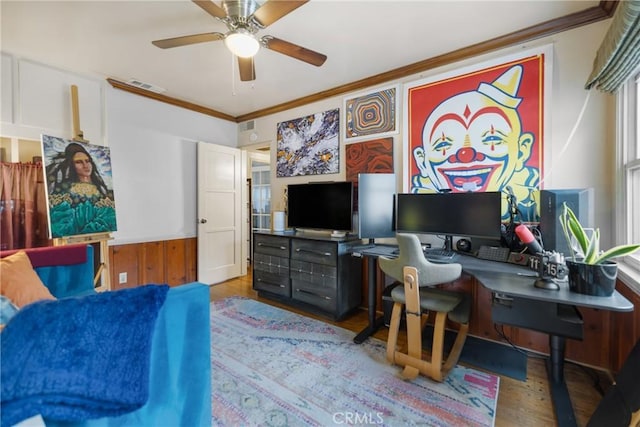 interior space with ceiling fan, ornamental molding, and hardwood / wood-style floors