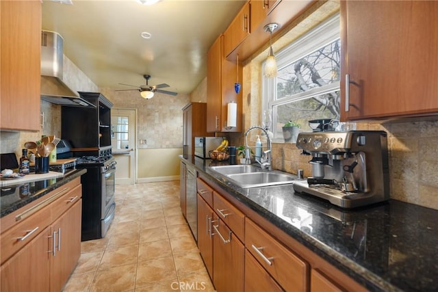 kitchen with pendant lighting, wall chimney range hood, sink, appliances with stainless steel finishes, and plenty of natural light