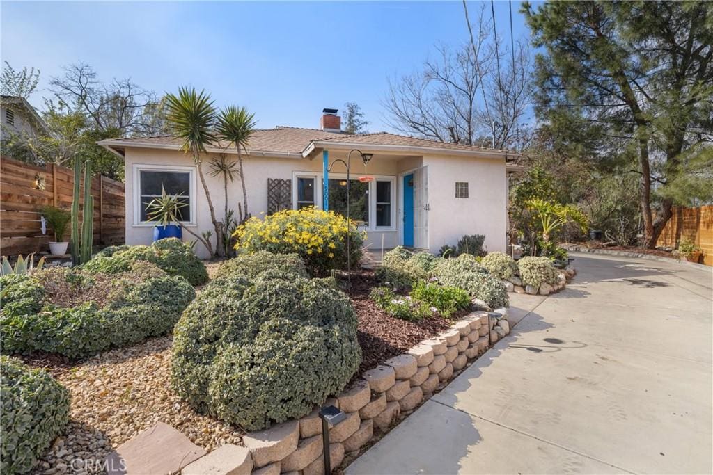 single story home with fence, a chimney, and stucco siding