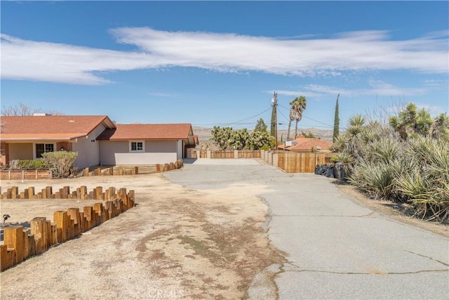 56766 Golden Bee Dr, Yucca Valley, CA 92284 - view of front of property with fence and stucco siding