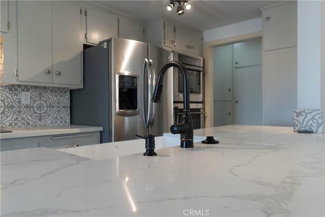 56766 Golden Bee Dr, Yucca Valley, CA 92284 - kitchen with appliances with stainless steel finishes, backsplash, light stone countertops, and gray cabinetry