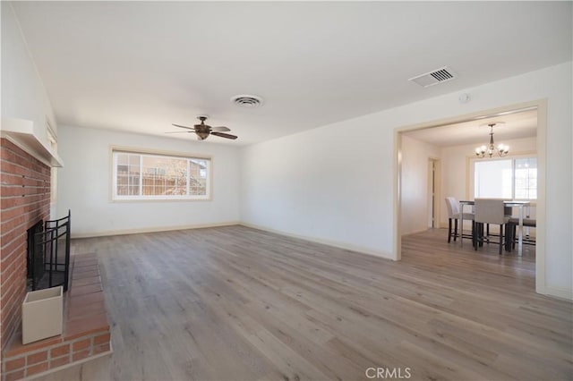 56766 Golden Bee Dr, Yucca Valley, CA 92284 - unfurnished living room with wood finished floors, a chandelier, baseboards, and a fireplace