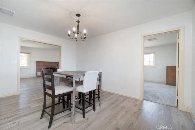 56766 Golden Bee Dr, Yucca Valley, CA 92284 - dining space with healthy amount of natural light, a chandelier, light wood finished floors, and baseboards