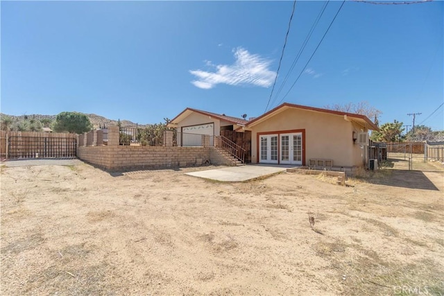 56766 Golden Bee Dr, Yucca Valley, CA 92284 - rear view of property with french doors, a gate, fence, and stucco siding