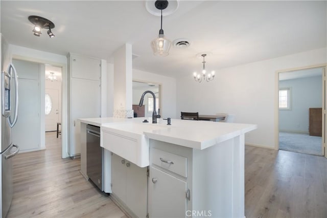 56766 Golden Bee Dr, Yucca Valley, CA 92284 - kitchen featuring stainless steel appliances, light wood-style floors, hanging light fixtures, and light countertops