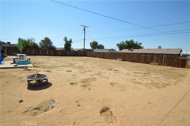 view of yard featuring an outdoor fire pit and fence