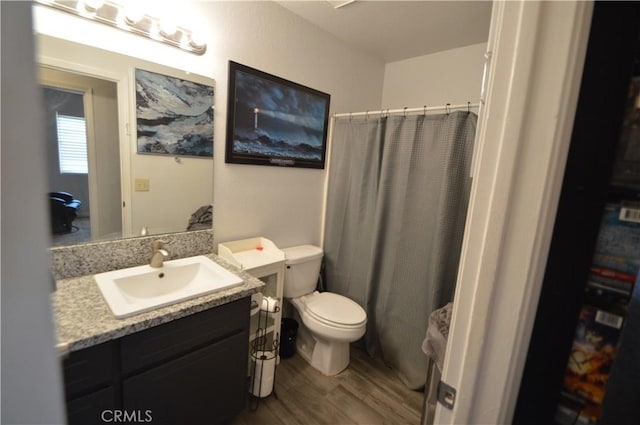 full bathroom featuring toilet, curtained shower, wood finished floors, and vanity