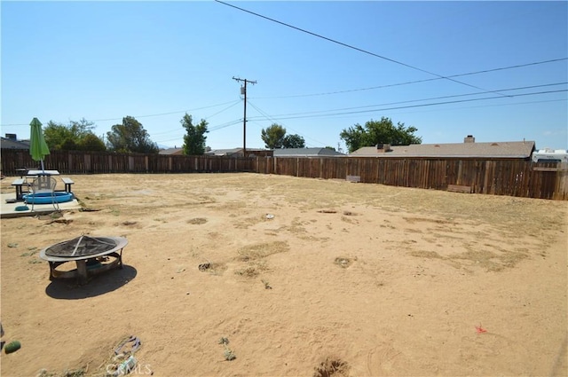 view of yard featuring fence and a fire pit