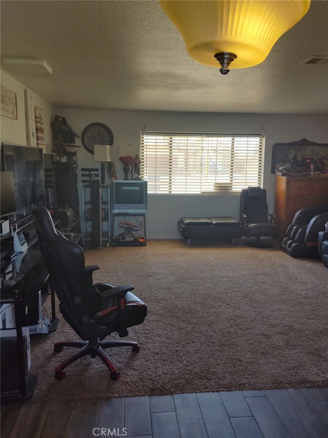 interior space with visible vents, a textured ceiling, and wood finished floors