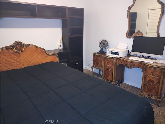 bedroom featuring dark carpet and baseboards