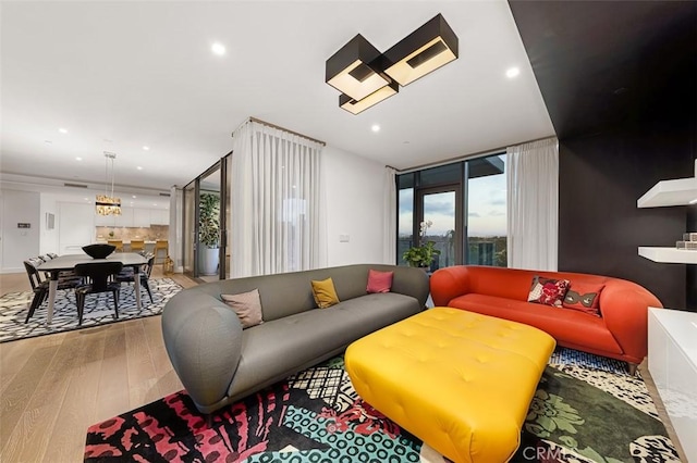 living room with recessed lighting, a wall of windows, and wood-type flooring