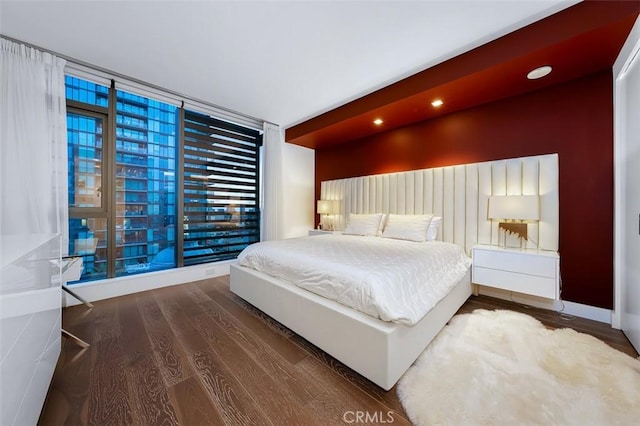 bedroom featuring recessed lighting, wood finished floors, and a wall of windows