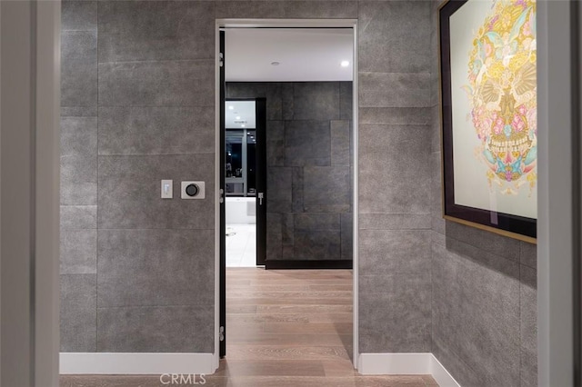 bathroom with tile walls and wood finished floors