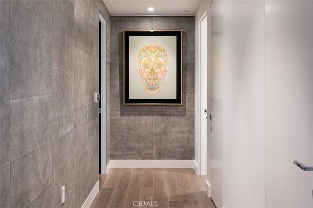 hall featuring recessed lighting and tile walls