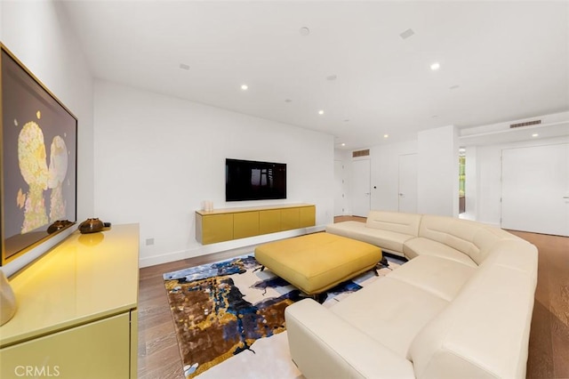 living room with visible vents, recessed lighting, and wood finished floors