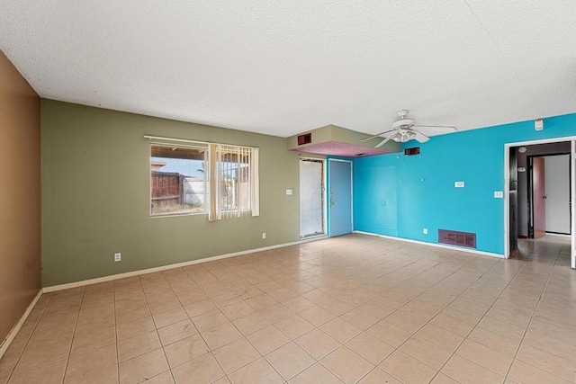 tiled empty room featuring a textured ceiling and ceiling fan