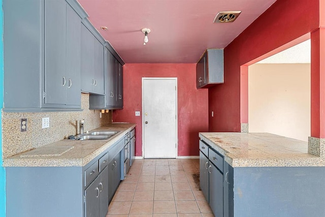 kitchen with backsplash, sink, and light tile patterned floors