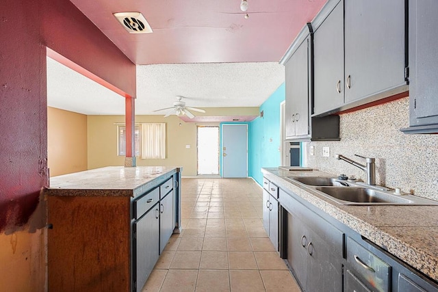 kitchen featuring sink, tasteful backsplash, a textured ceiling, light tile patterned floors, and ceiling fan