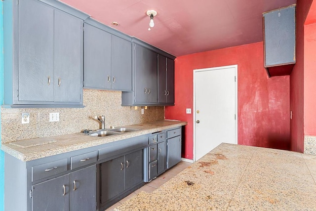 kitchen featuring gray cabinets, sink, and decorative backsplash