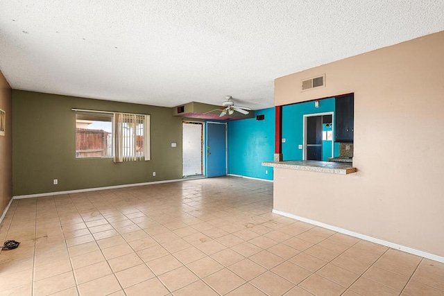 tiled empty room featuring a textured ceiling and ceiling fan