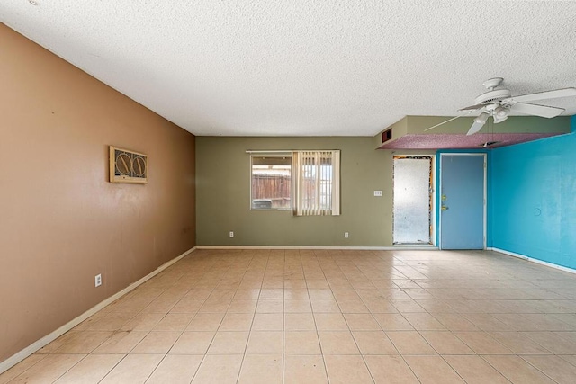 tiled spare room with a textured ceiling and ceiling fan