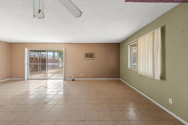 tiled empty room with a textured ceiling