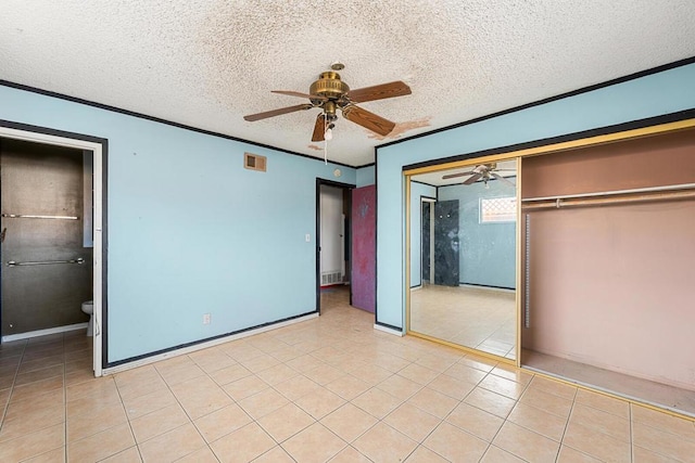 unfurnished bedroom with light tile patterned floors, ceiling fan, crown molding, a textured ceiling, and a closet