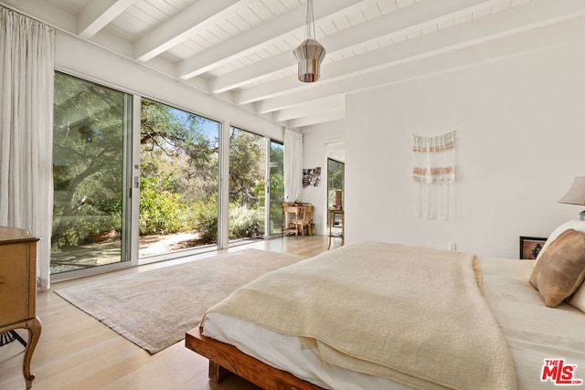 bedroom featuring beamed ceiling, light hardwood / wood-style floors, and access to outside