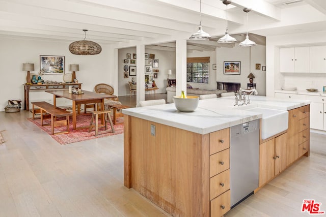 kitchen with sink, white cabinetry, decorative light fixtures, stainless steel dishwasher, and a kitchen island with sink