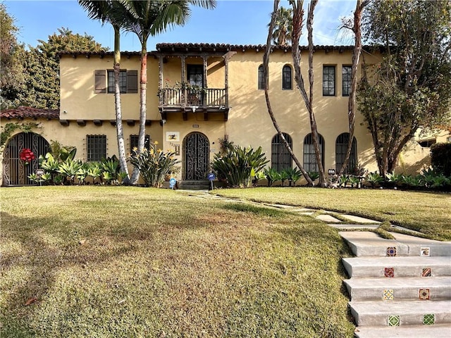 view of front of property with a balcony and a front yard