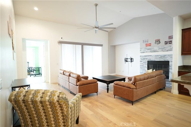 living room featuring ceiling fan, vaulted ceiling, and light wood-type flooring