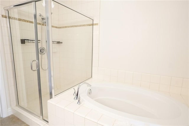 bathroom featuring separate shower and tub