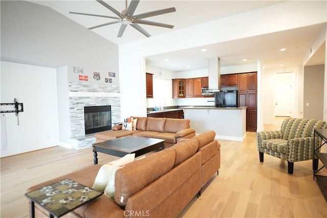 living room with lofted ceiling, light hardwood / wood-style flooring, and ceiling fan