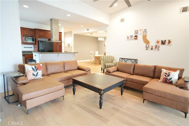 living room featuring ceiling fan and light hardwood / wood-style flooring