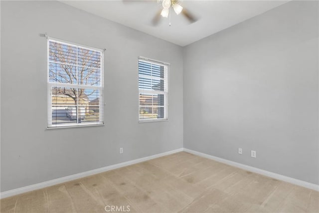 spare room with ceiling fan and light colored carpet