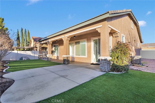 back of house with a patio and a yard