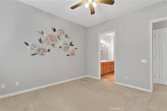 unfurnished bedroom with connected bathroom, light carpet, and ceiling fan