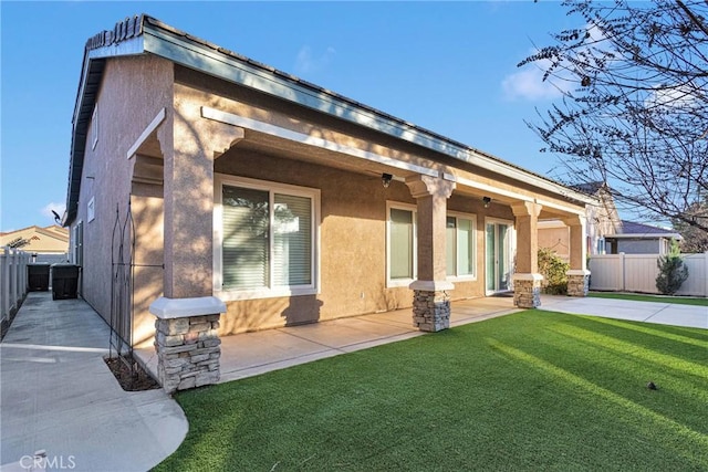 rear view of house featuring a yard and a patio area