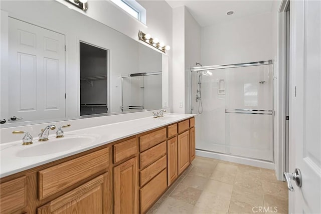 bathroom featuring a shower with door and vanity