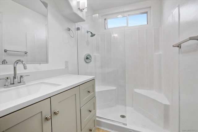 bathroom with a shower with door and vanity