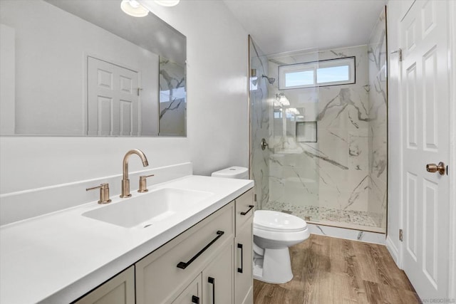 bathroom with wood-type flooring, toilet, a shower with door, and vanity