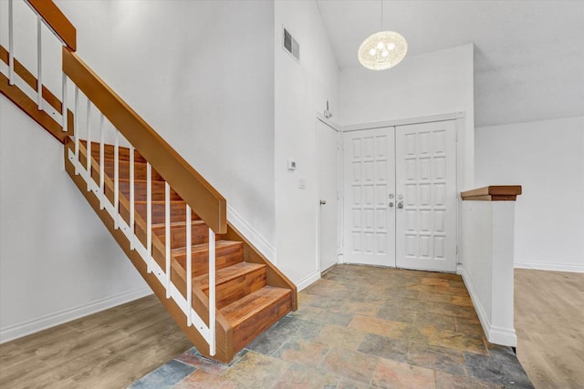 entryway with a high ceiling and a notable chandelier