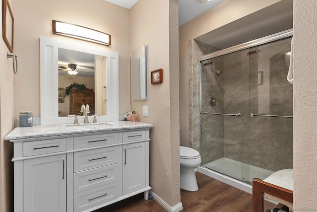 bathroom with an enclosed shower, vanity, hardwood / wood-style flooring, and ceiling fan