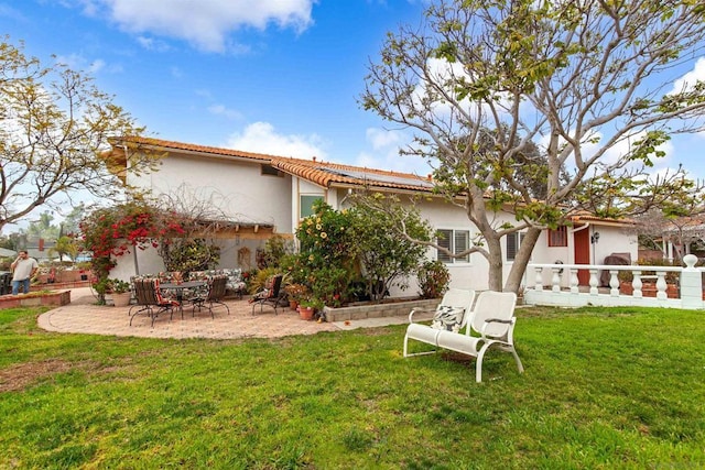 rear view of house with a yard and a patio area