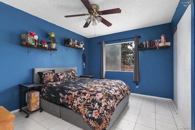 bedroom featuring ceiling fan, a textured ceiling, and light tile patterned floors