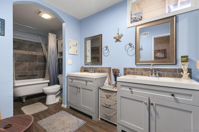 full bathroom featuring shower / bath combo, hardwood / wood-style floors, vanity, and toilet