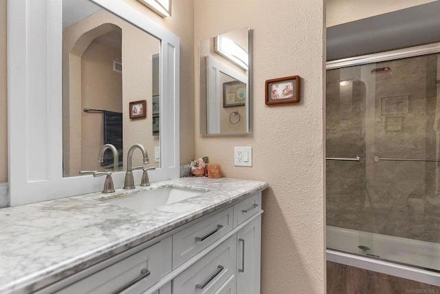 bathroom featuring vanity and a shower with shower door